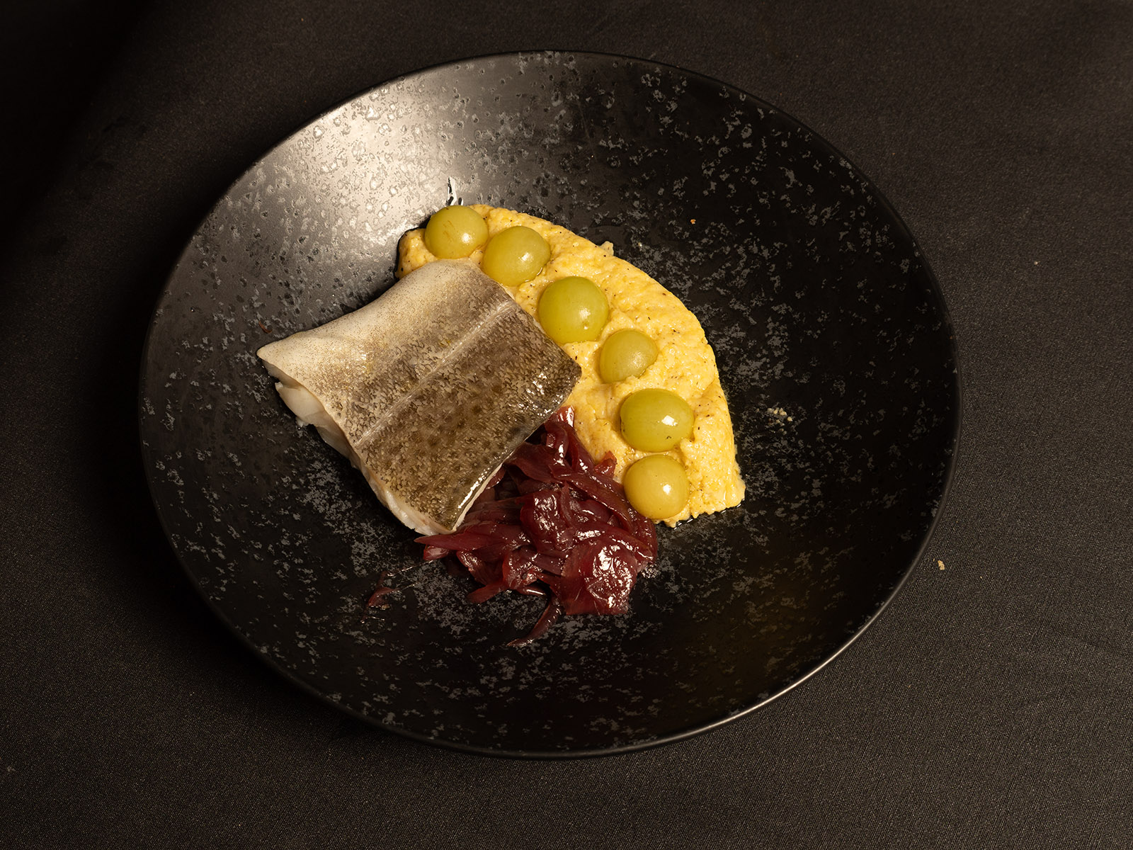 Filetto di merluzzo con polenta di Beura, cipolle e uva